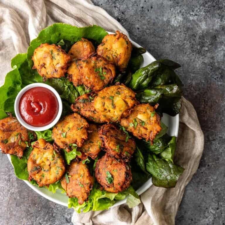 Crispy fried fritters made with a mixture of spices, herbs, and vegetables, often served as a snack or appetizer. Crispy fried fritters made with a mixture of spices, herbs, and vegetables, often served as a snack or appetizer.